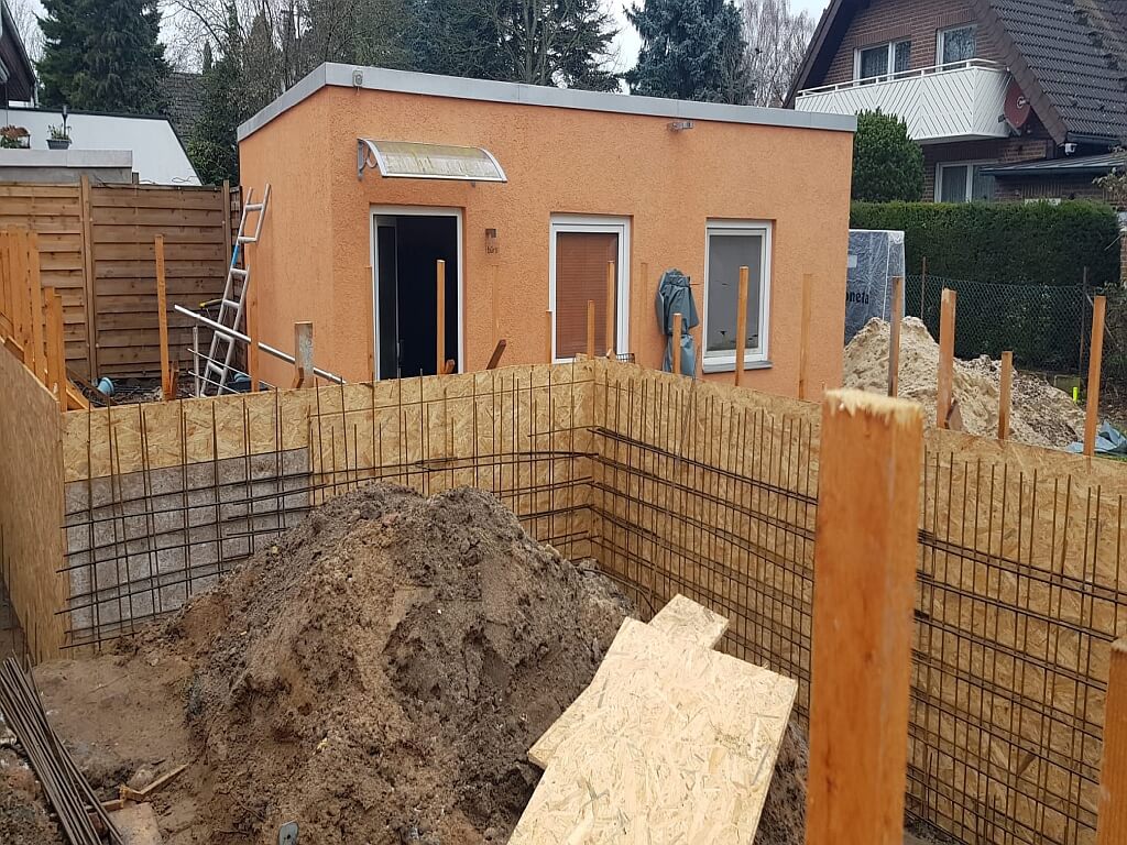 Gartenansicht und Gründungsarbeiten beim Anbau eines Einfamilienhauses in Berlin